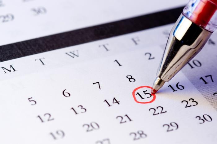 Red pen circling number 15 on a paper calendar